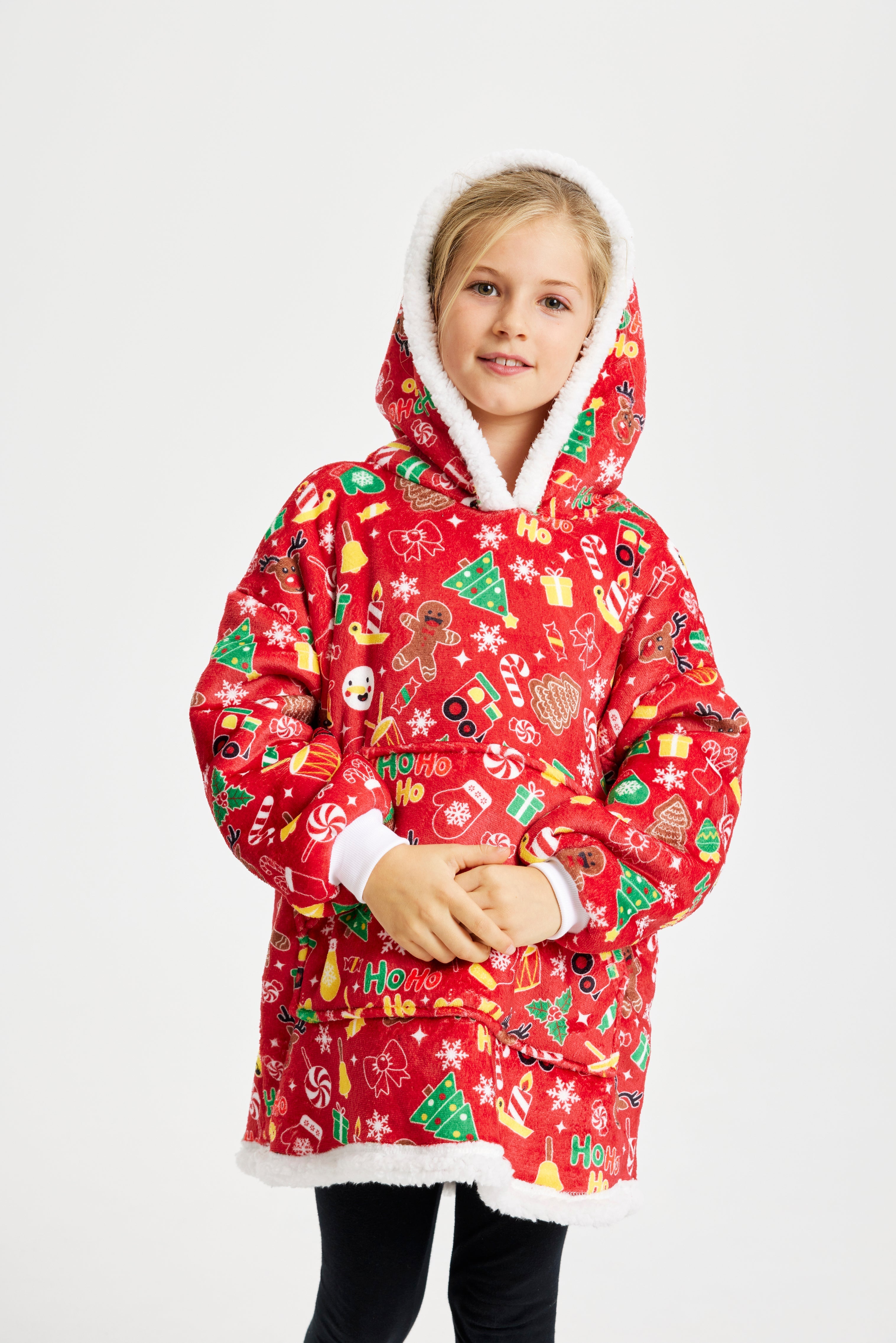 Et søtt barn med hendene samlet, iført en rød julegenser med julemønster.